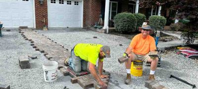 Two skilled workers using Paver blocks for walkway construction